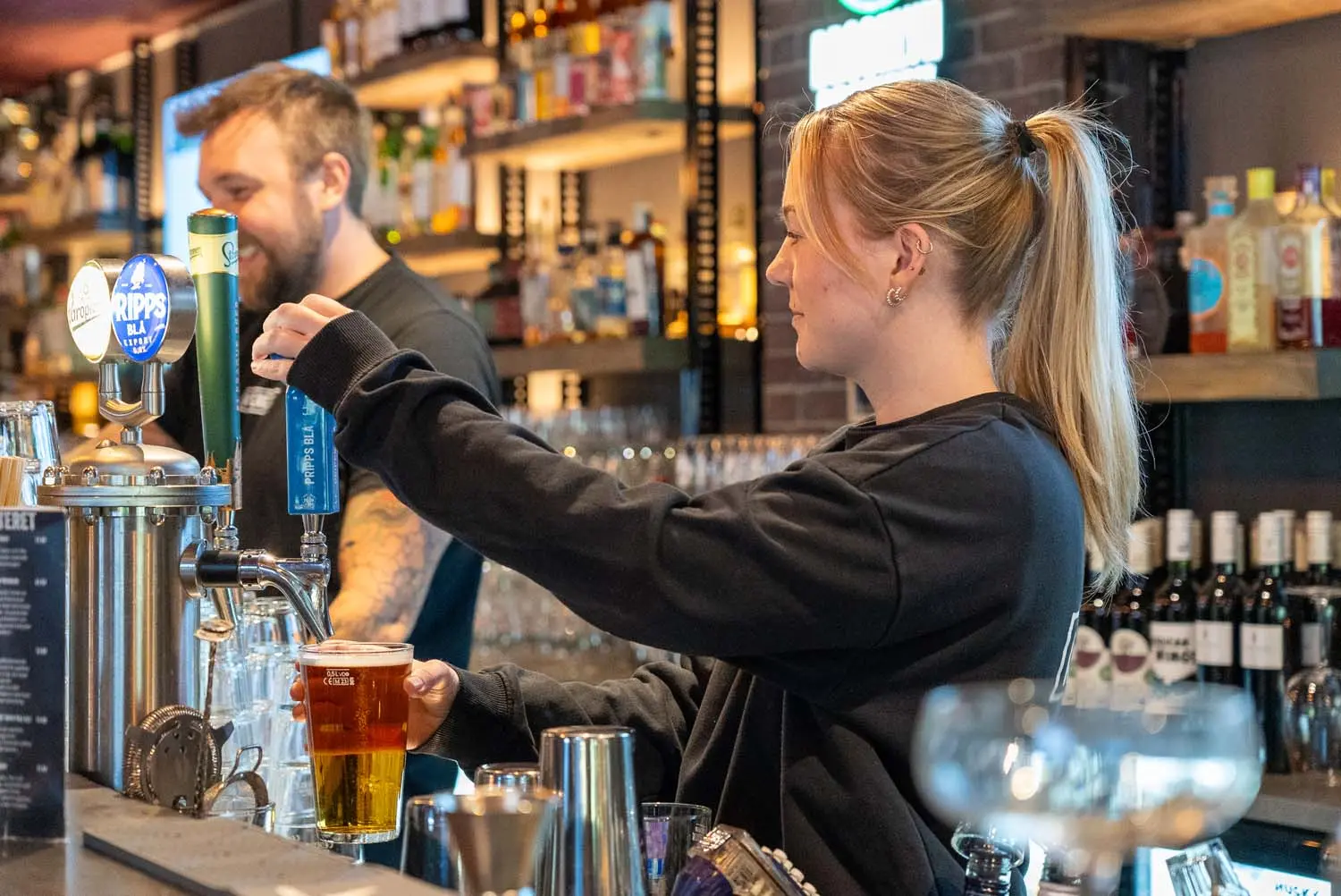 Restauranganställd använder HappyOrders digitala kassasystem för snabbare betalningar